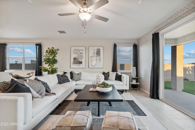 living room with a healthy amount of sunlight, light tile patterned floors, and ceiling fan