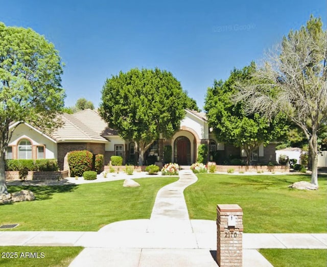 view of front of property featuring a front lawn and stucco siding