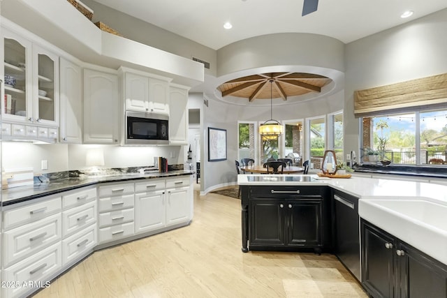 kitchen featuring built in microwave, white cabinets, and dark cabinets