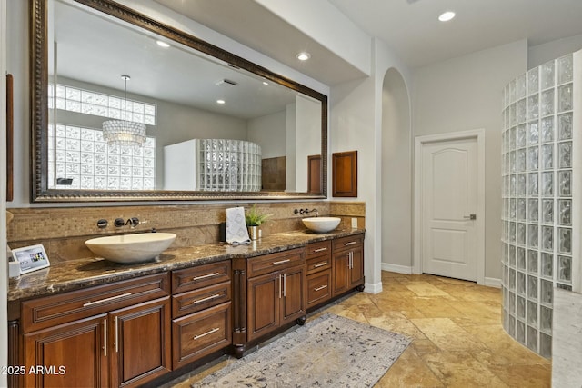 bathroom featuring recessed lighting, a sink, baseboards, and double vanity