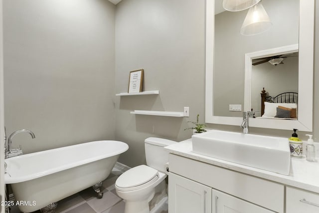 full bath featuring a freestanding bath, tile patterned flooring, vanity, and toilet