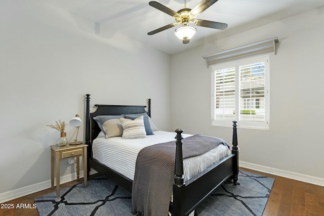 bedroom with ceiling fan, baseboards, and wood finished floors