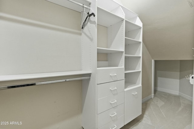 walk in closet featuring light carpet and vaulted ceiling