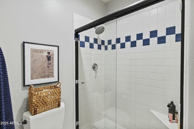 bathroom with a shower stall and toilet