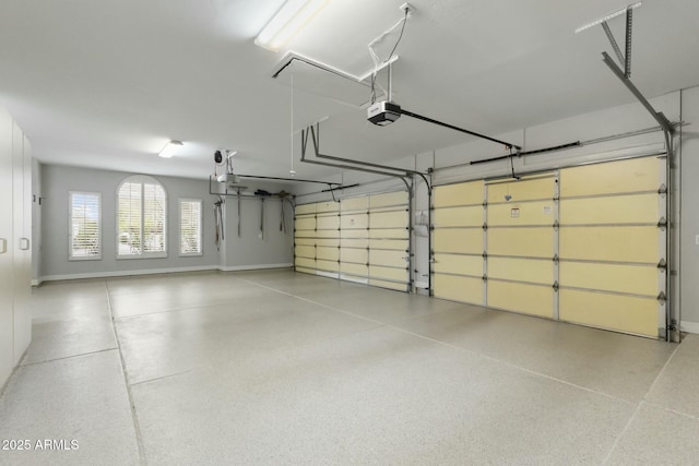 garage with a garage door opener and baseboards