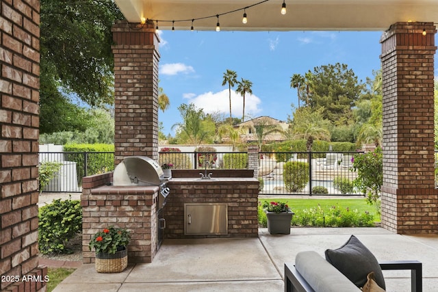 view of patio with a sink, grilling area, an outdoor kitchen, and fence