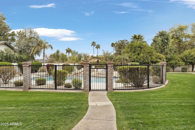 view of gate featuring a community pool, fence, and a yard