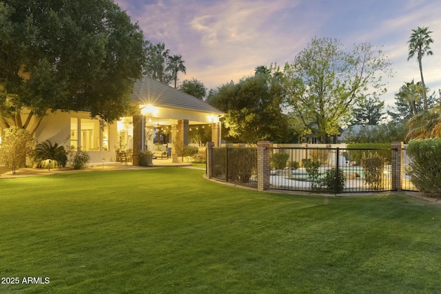 yard at dusk with a patio area and fence