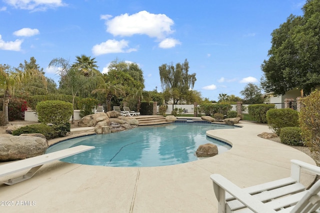 view of swimming pool featuring a patio area, fence, a diving board, and a fenced in pool