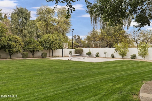 view of yard featuring a fenced backyard and basketball court