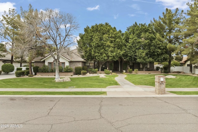 view of front of property with a front yard, fence, and stucco siding