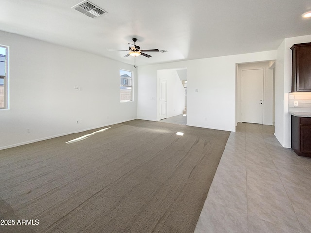 unfurnished living room featuring ceiling fan and light tile patterned floors