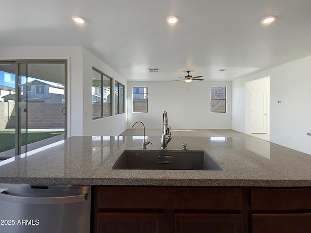 kitchen featuring sink, dishwasher, a healthy amount of sunlight, and light stone counters