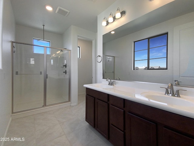 bathroom with a wealth of natural light, a shower with door, and vanity