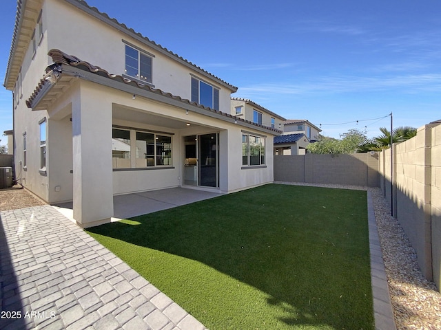 rear view of house featuring a patio, central AC unit, and a yard