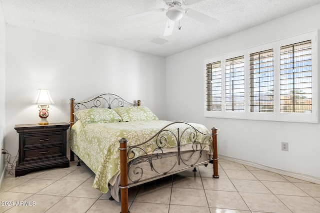 tiled bedroom with ceiling fan and a textured ceiling