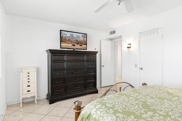 tiled bedroom featuring ceiling fan and a textured ceiling