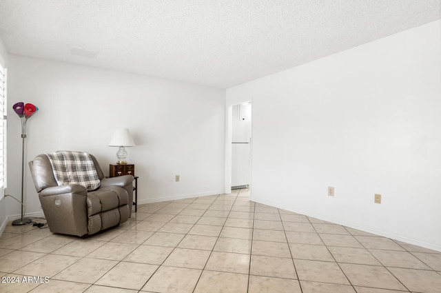 living area with light tile patterned floors and a textured ceiling