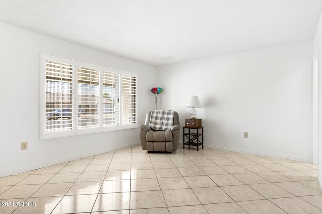 unfurnished room with light tile patterned floors and a textured ceiling