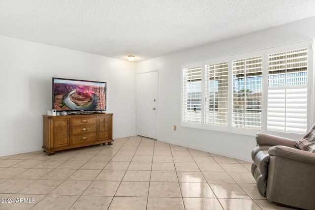 interior space with light tile patterned floors and a textured ceiling