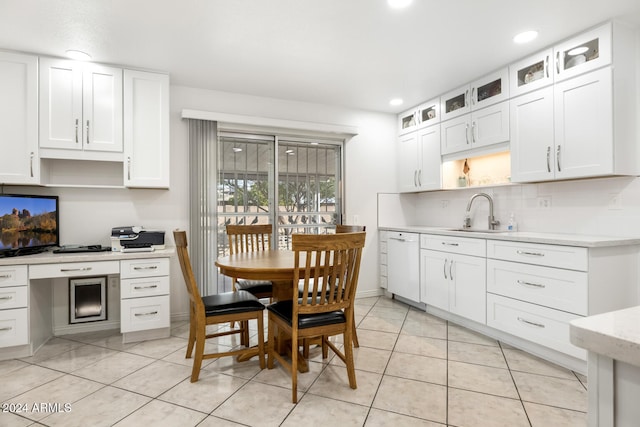 kitchen featuring decorative backsplash, white cabinetry, sink, and light tile patterned flooring