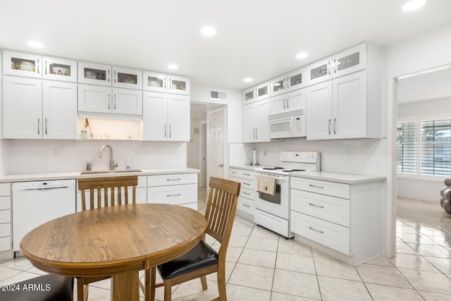 kitchen featuring white cabinetry, sink, light tile patterned floors, and white appliances