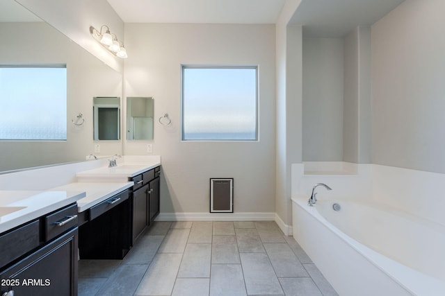 bathroom with tile patterned floors, vanity, and a bathing tub