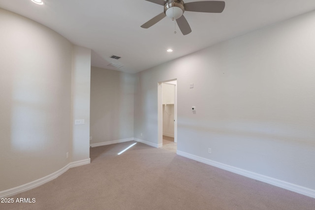 spare room with ceiling fan and light colored carpet