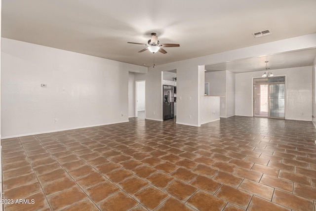 unfurnished living room with dark tile patterned flooring and ceiling fan with notable chandelier