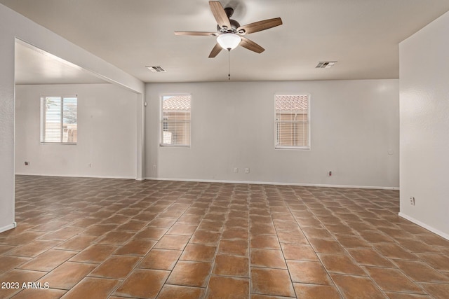 spare room with dark tile patterned floors and ceiling fan