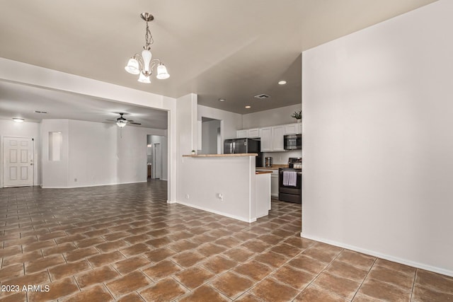 unfurnished living room with ceiling fan with notable chandelier and dark tile patterned floors