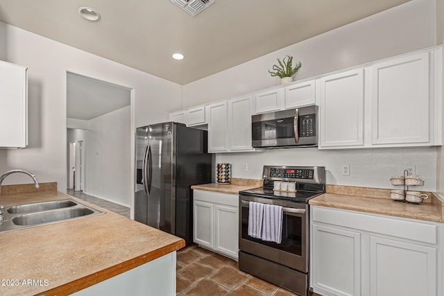 kitchen with sink, white cabinets, and appliances with stainless steel finishes