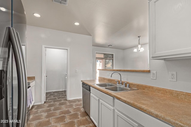 kitchen featuring sink, white cabinetry, black fridge, decorative light fixtures, and stainless steel dishwasher