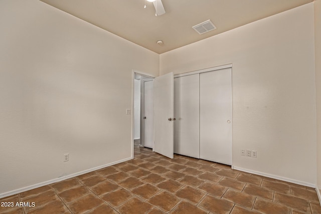 unfurnished bedroom with ceiling fan and a closet