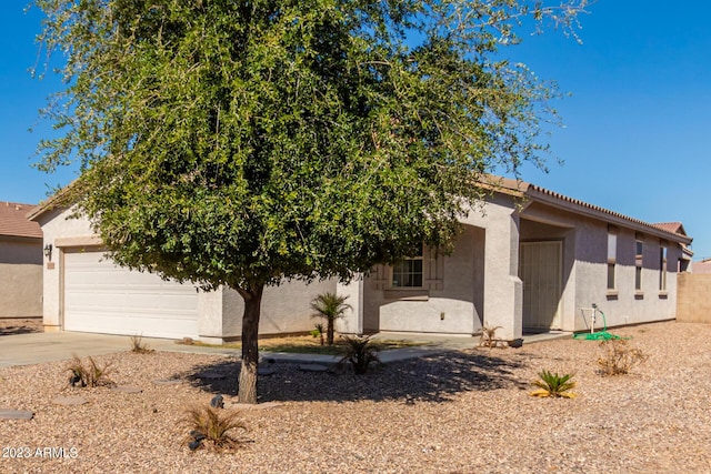 view of property hidden behind natural elements with a garage