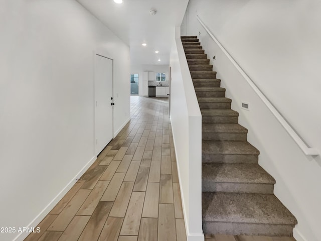 stairs with wood tiled floor, baseboards, and recessed lighting