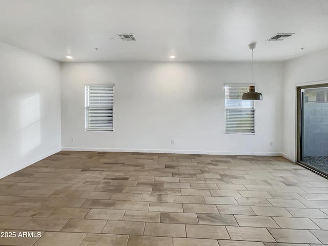 empty room with recessed lighting, visible vents, and baseboards