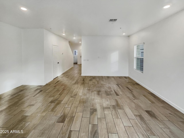 empty room with light wood-style flooring, visible vents, and recessed lighting