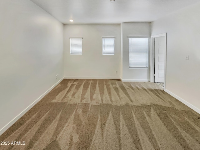 unfurnished room with carpet floors and baseboards