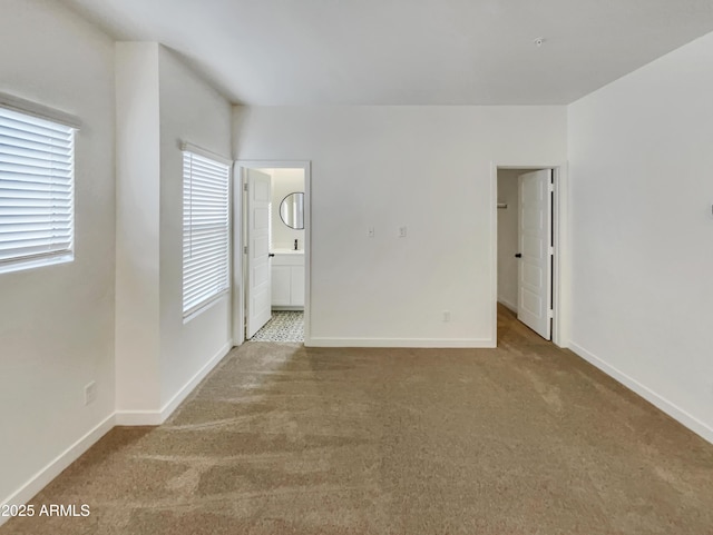 unfurnished room with light colored carpet and baseboards