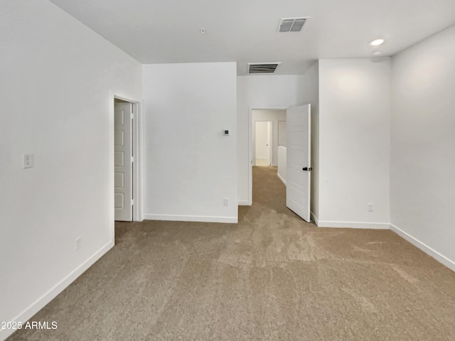 interior space featuring light colored carpet, visible vents, and baseboards