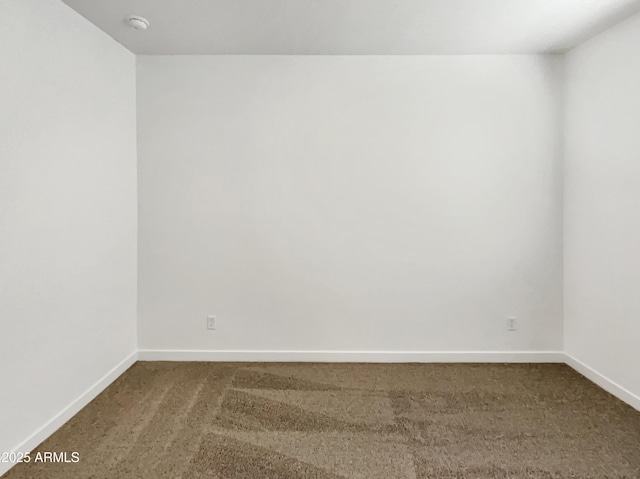 carpeted empty room featuring baseboards