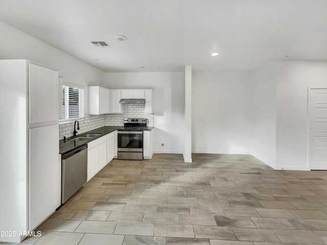 kitchen with under cabinet range hood, stainless steel appliances, a sink, visible vents, and white cabinets