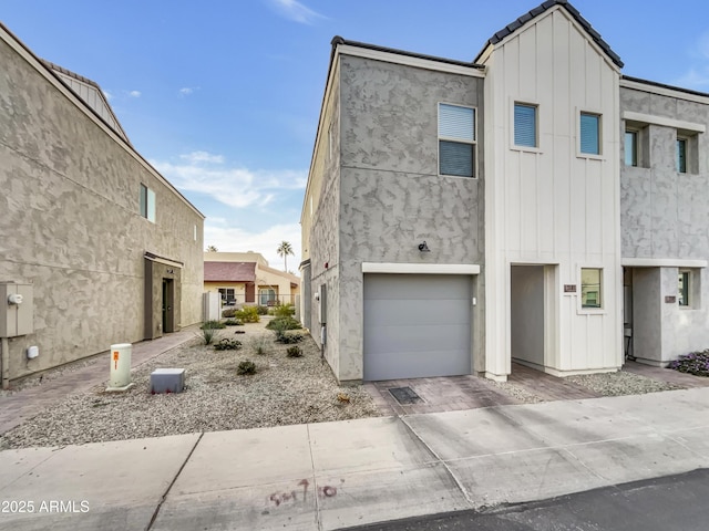 multi unit property with a garage, board and batten siding, and stucco siding