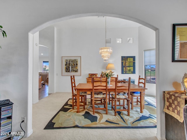 carpeted dining space with an inviting chandelier