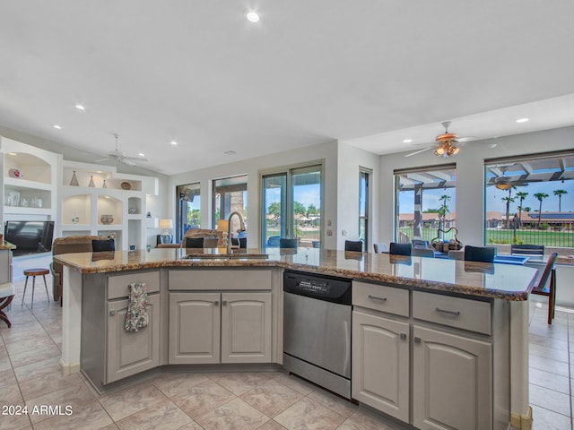 kitchen with an island with sink, ceiling fan, sink, and stainless steel dishwasher