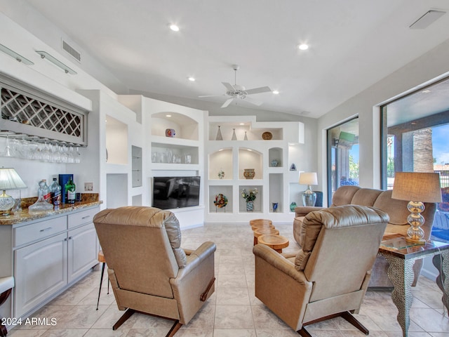 living room with ceiling fan, light tile patterned flooring, a fireplace, and vaulted ceiling