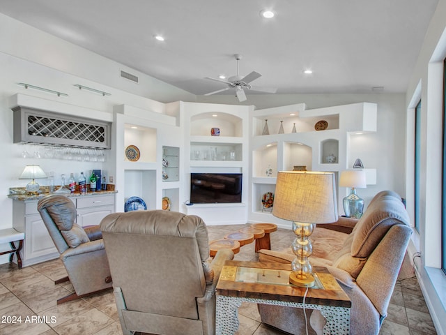 living room with built in shelves, lofted ceiling, ceiling fan, and bar