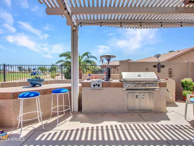 view of patio / terrace with grilling area, an outdoor kitchen, and a pergola