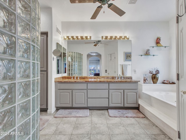 bathroom featuring ceiling fan, vanity, a bathtub, and tile patterned floors